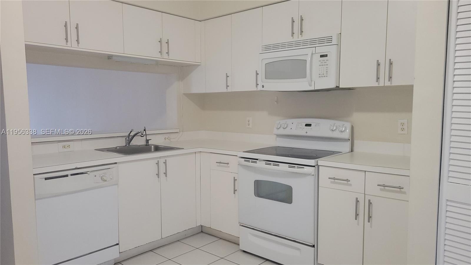 A kitchen features white cabinets, white appliances, and white countertops with a tiled floor — 16679 Hemingway Dr, Weston FL 33326, WESTON, FL