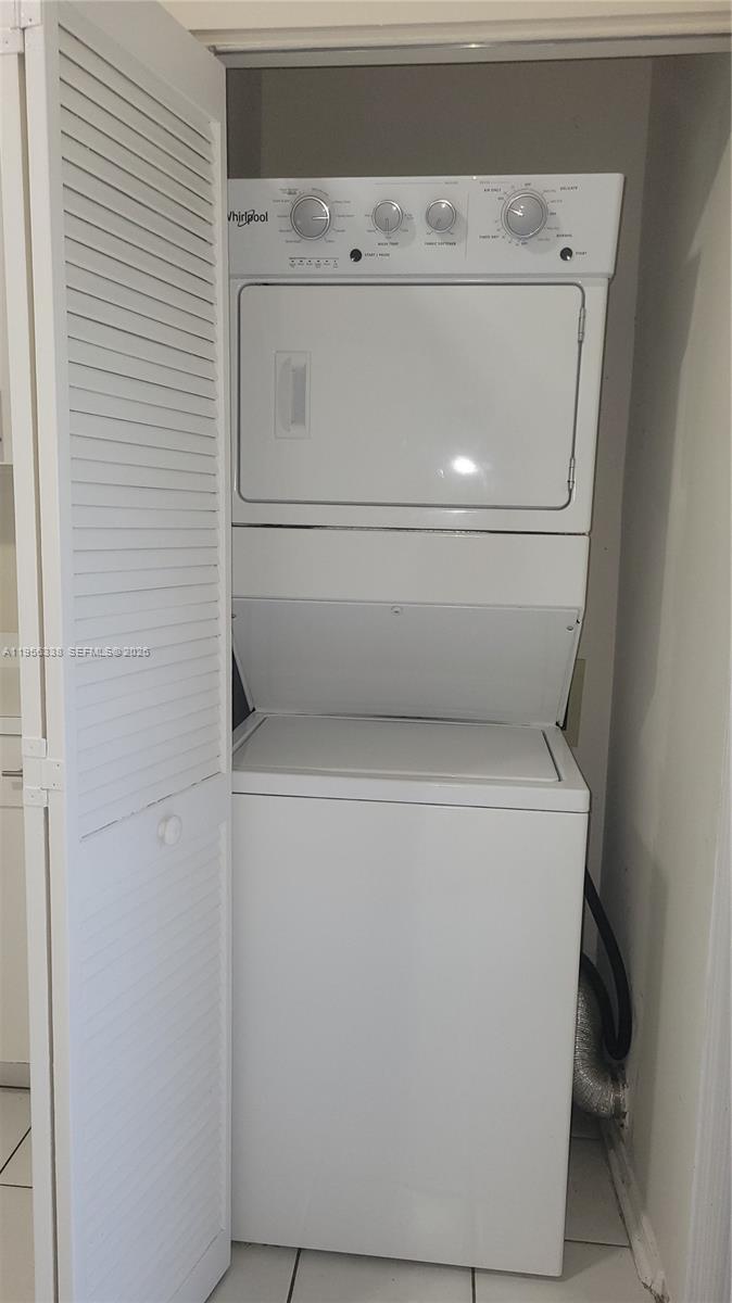 A white stackable Whirlpool washer and dryer unit sits inside a closet with louvered doors — 16679 Hemingway Dr, Weston FL 33326, WESTON, FL