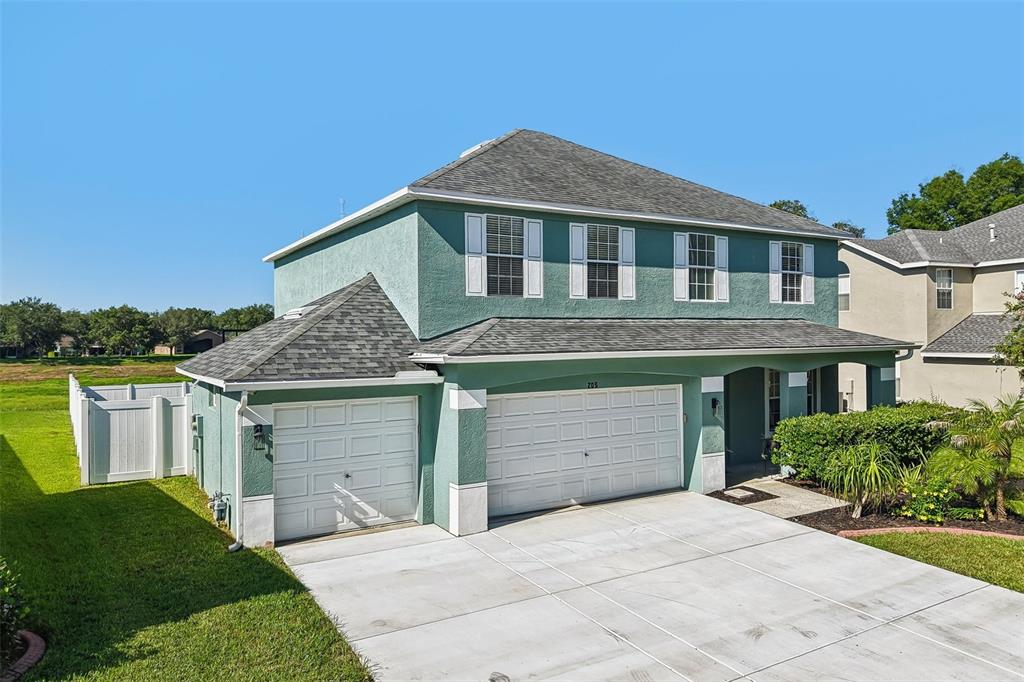 A two-story house with teal stucco, a two-car garage, and a front porch — 205 ROSANA DRIVE, BRANDON, FL