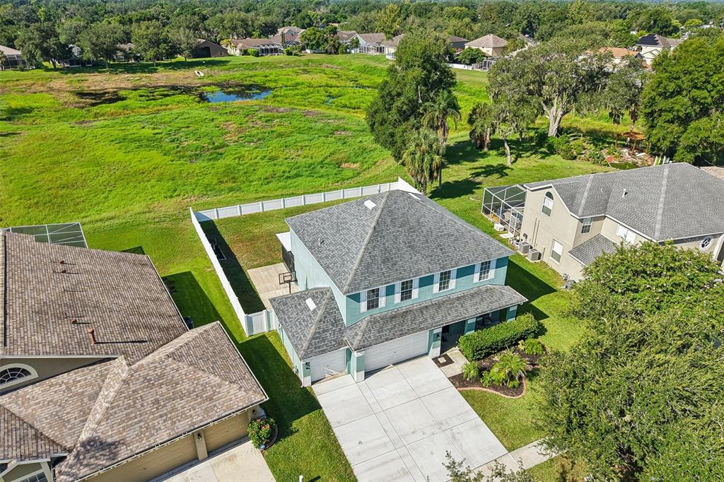 An aerial view shows a two-story house with a fenced backyard and a concrete driveway — 205 ROSANA DRIVE, BRANDON, FL