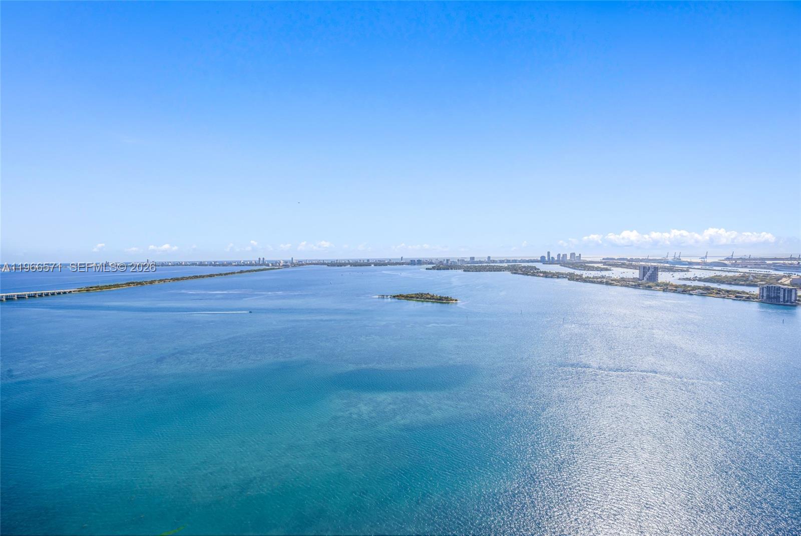 An aerial view shows a large body of water with a small island and distant coastline — 700 NE 24th St # 4007, Miami FL 33137, MIAMI, FL
