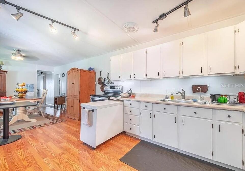 A kitchen features white cabinets, a small island, and wood-look flooring — 2360 LAKEVIEW DRIVE, HAINES CITY, FL