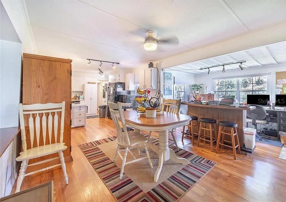 A dining area with a wooden table and chairs sits on a rug near a kitchen — 2360 LAKEVIEW DRIVE, HAINES CITY, FL