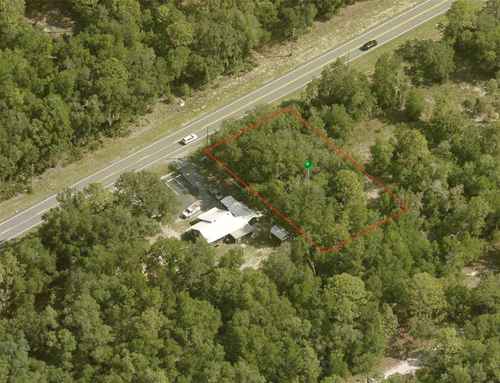 An aerial view shows a wooded lot outlined in red next to a house — 7622 W DUNNELLON ROAD, DUNNELLON, FL