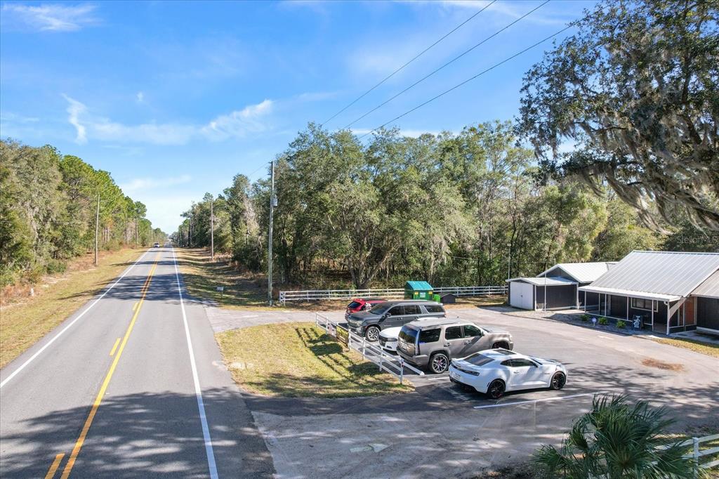 An aerial view shows a rural road next to a parking lot with several parked cars — 7622 W DUNNELLON ROAD, DUNNELLON, FL