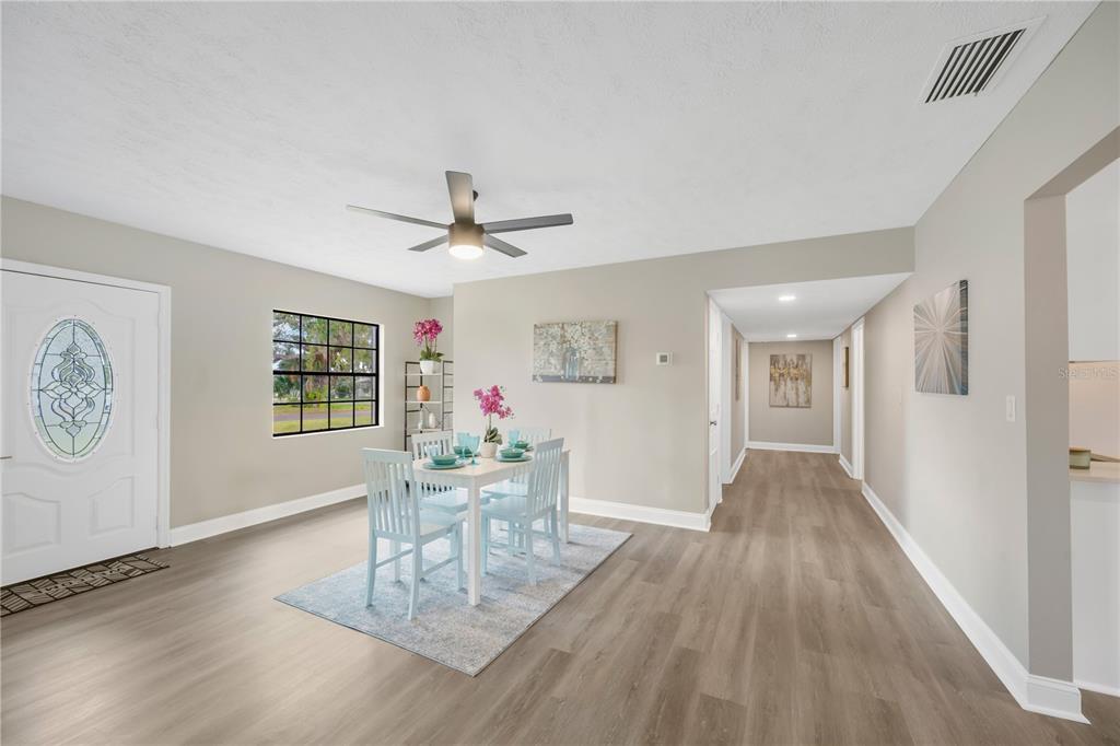 A dining area features light wood flooring, a white table with chairs, and a ceiling fan — 7502 LONE STAR PLACE, RIVERVIEW, FL