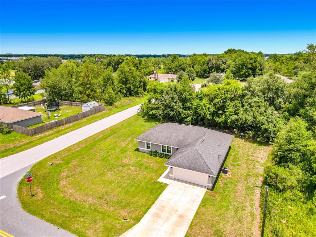 An aerial view shows a single-story house with a gray roof and a concrete driveway — 33 JUNIPER PASS TERRACE, OCALA, FL