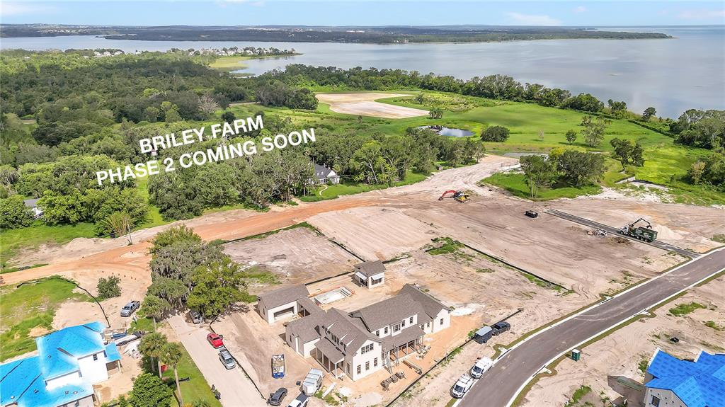 An aerial view shows a construction site with new houses and a lake in the background — 514 N POLLARD STREET, OAKLAND, FL