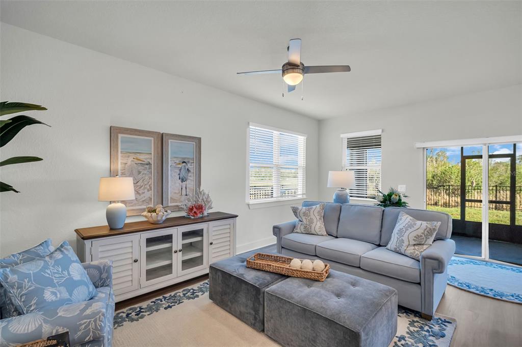 A living room features a light blue sofa, a gray ottoman, and a white console — 13978 EMERALD FIELDS DRIVE Lot 25, HUDSON, FL