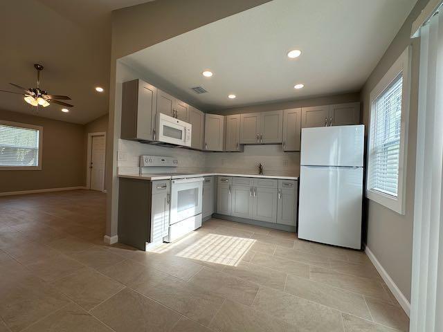 A kitchen features gray cabinets, white appliances, and light-colored tile flooring — 3166 SE Garden Street # 3166, Stuart FL 34997, STUART, FL