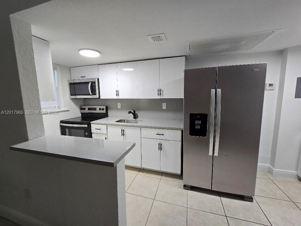 A kitchen features white cabinets, stainless steel appliances, and a breakfast bar — 3901 SW 112th Ave # 38, Miami FL 33165, MIAMI, FL