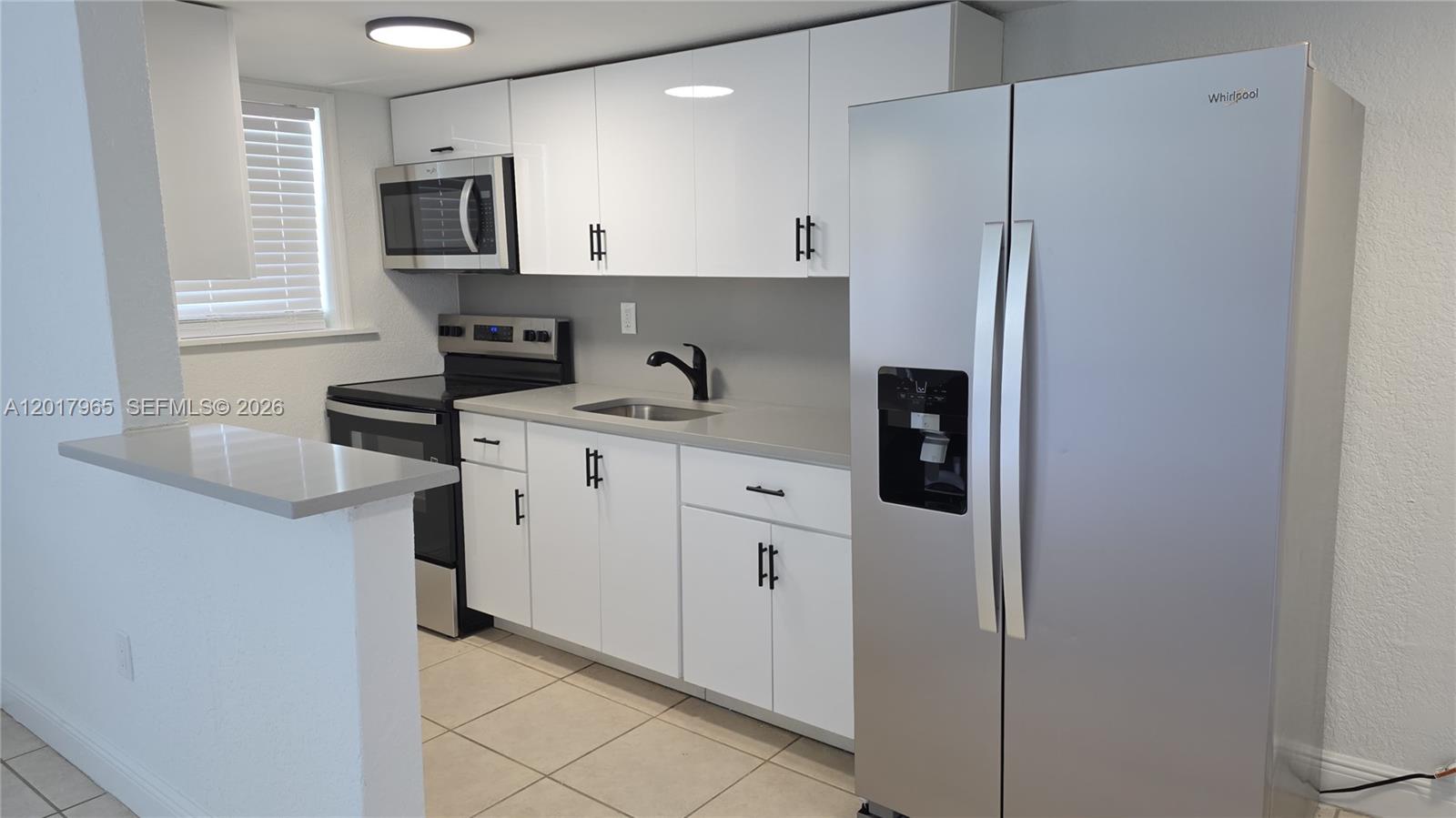 A kitchen features white cabinets, stainless steel appliances, a gray countertop, and tile flooring — 3901 SW 112th Ave # 38, Miami FL 33165, MIAMI, FL