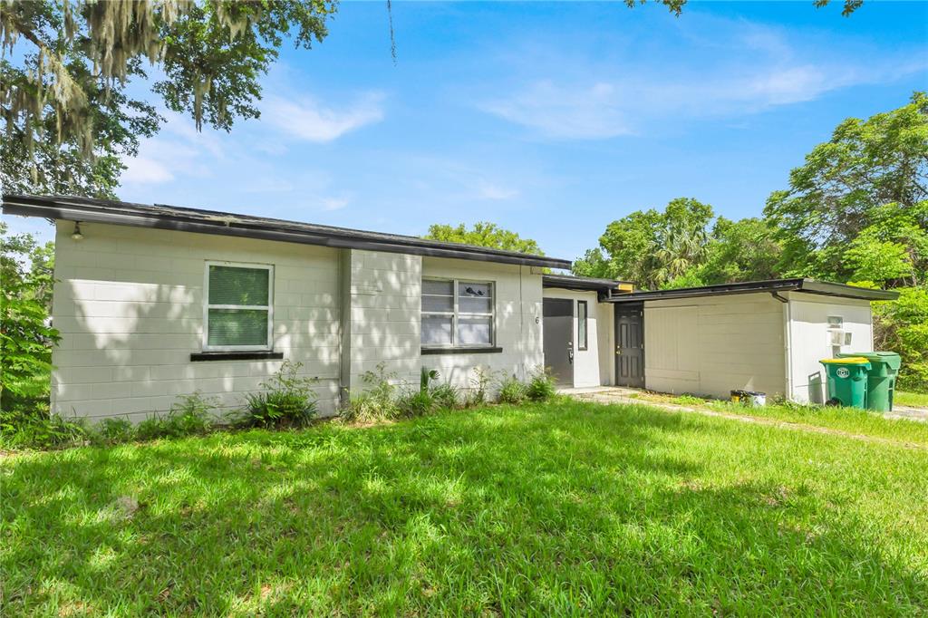 A single-story concrete block house with a flat roof and a green lawn — 226 S HILL AVENUE, DELAND, FL