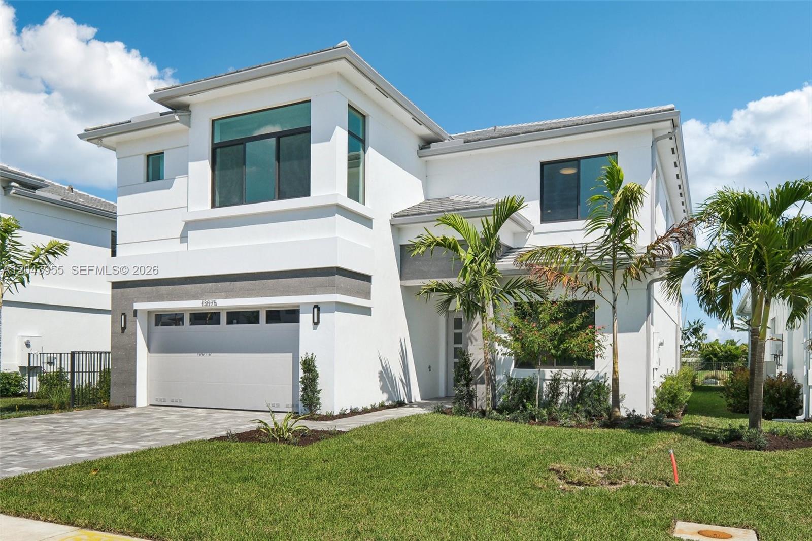 A two-story modern house with a white exterior, a two-car garage, and palm trees — 13075 Feathering Way, Palm Beach Gardens FL 33412, PALM BEACH GARDENS, FL