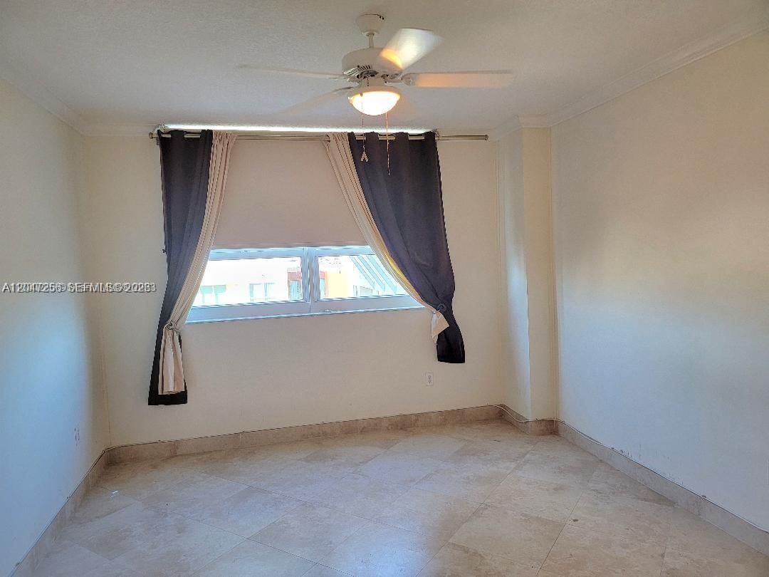 A bedroom features light-colored tile flooring, white walls, and a window with dark curtains — 2000 N Bayshore Dr # 707, Miami FL 33137, MIAMI, FL