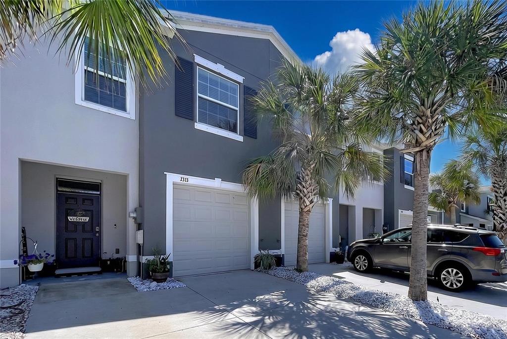 A two-story gray townhouse with a garage, a front door, and palm trees in front — 3313 PLEASANT WILLOW COURT, BRANDON, FL