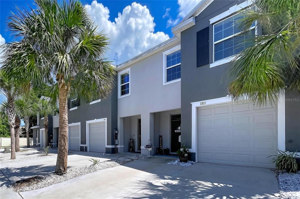 A row of two-story townhomes with gray and white facades, garages, and palm trees — 3313 PLEASANT WILLOW COURT, BRANDON, FL