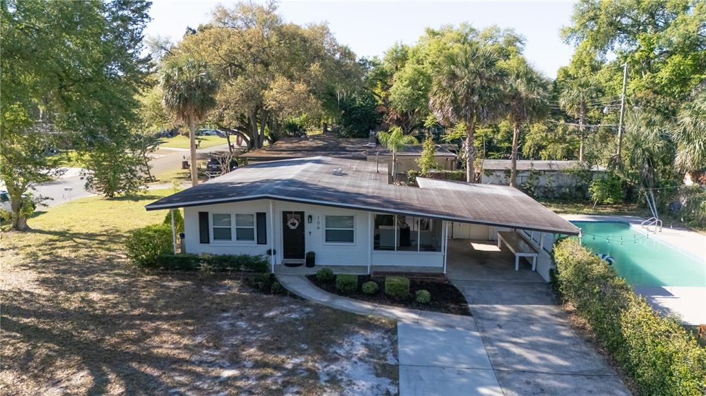 An aerial view of a white single-story house with a carport and a swimming pool — 106 E JINKINS CIRCLE, SANFORD, FL