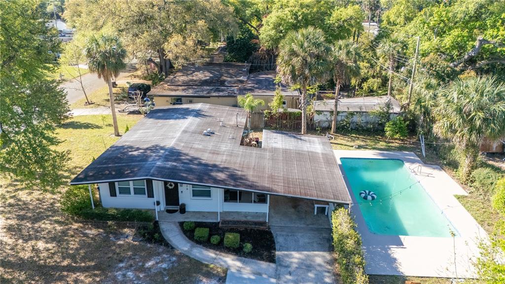 An aerial view shows a single-story house with a flat roof, carport, and swimming pool — 106 E JINKINS CIRCLE, SANFORD, FL
