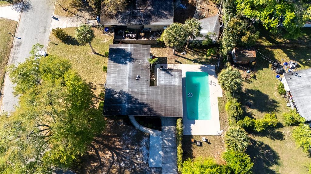 An aerial view shows a house with a flat roof, a swimming pool, and trees — 106 E JINKINS CIRCLE, SANFORD, FL