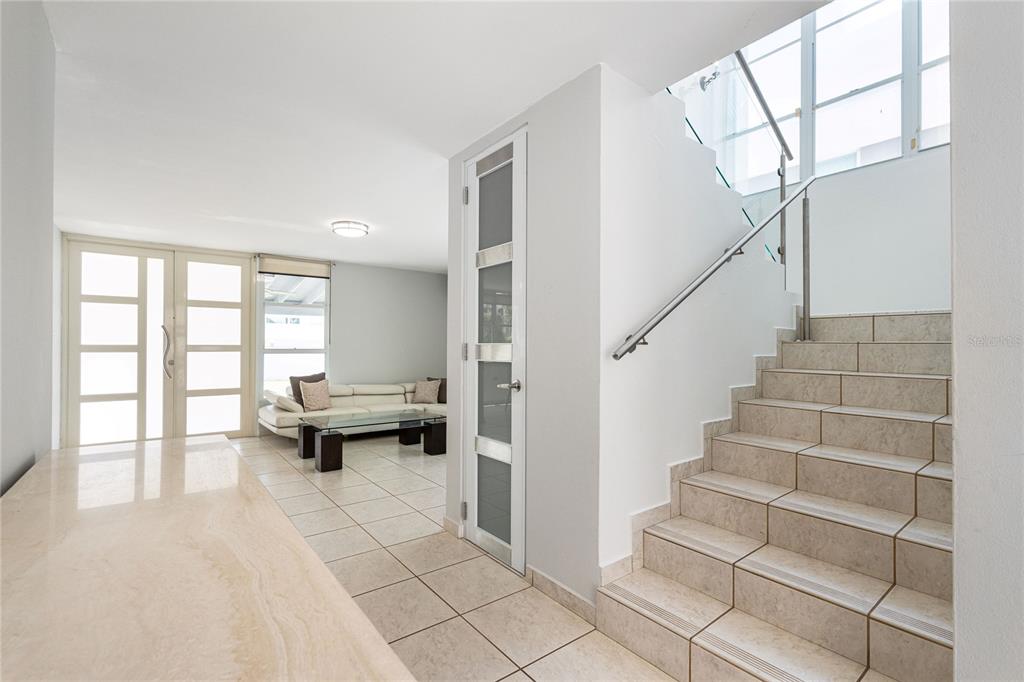 A tiled entryway features a staircase with a metal railing and a view into a living room — 357 SABALO STREET, DORADO, PR