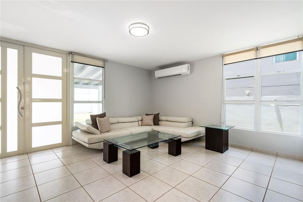 A living room features a white sectional sofa, glass coffee table, and light tile flooring — 357 SABALO STREET, DORADO, PR