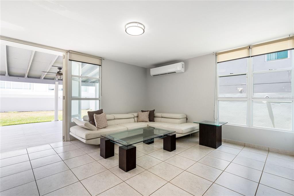 A living room features a white sectional sofa, glass coffee table, and light tile flooring — 357 SABALO STREET, DORADO, PR