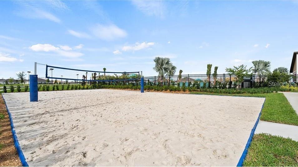 A sand volleyball court with a net is situated outdoors in a residential community — 3419 ROVER ROAD, EAGLE LAKE, FL