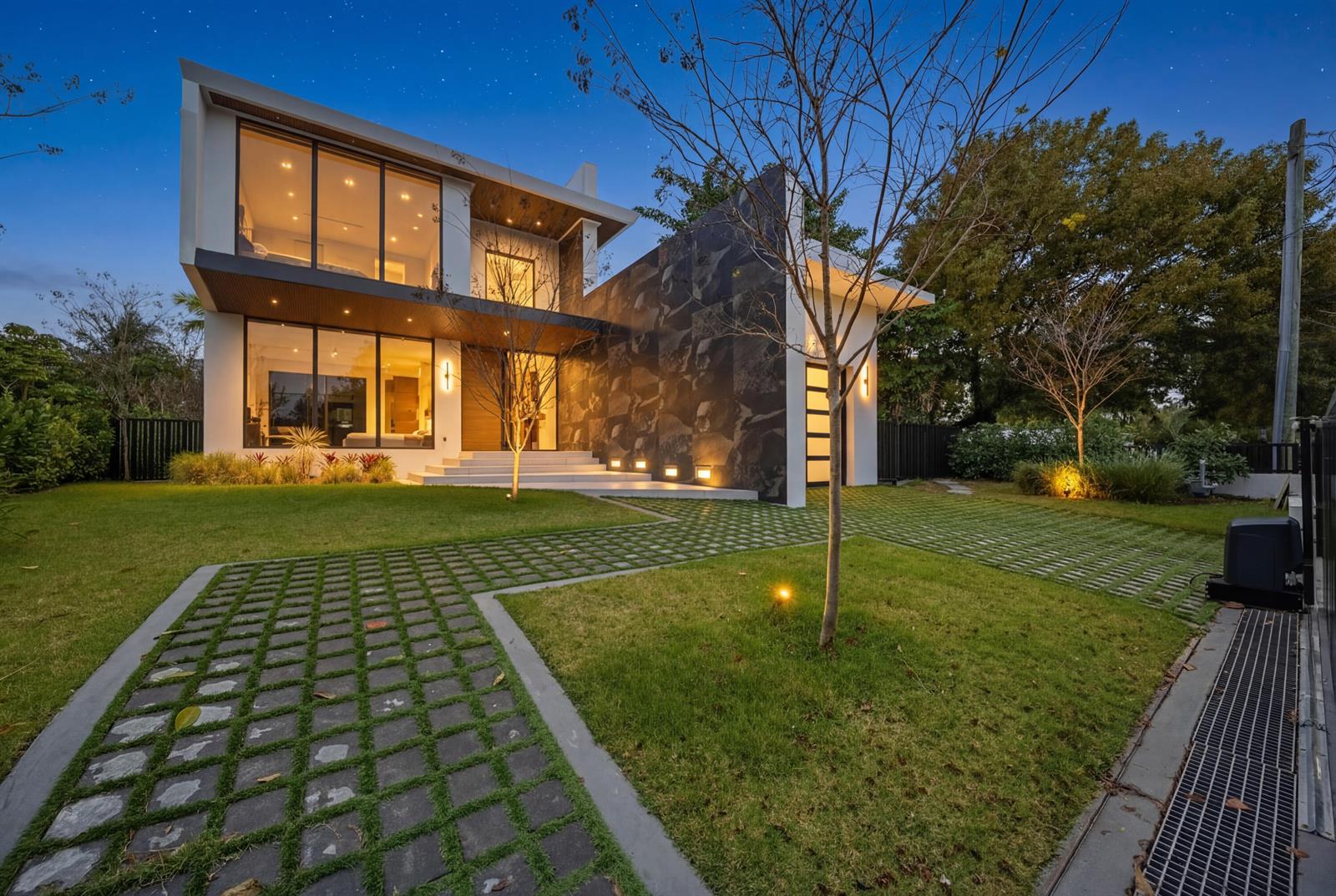 A modern two-story house with a stone facade, large glass windows, and a paved driveway — 930 S Shore Drive, Miami Beach FL 33141, MIAMI BEACH, FL