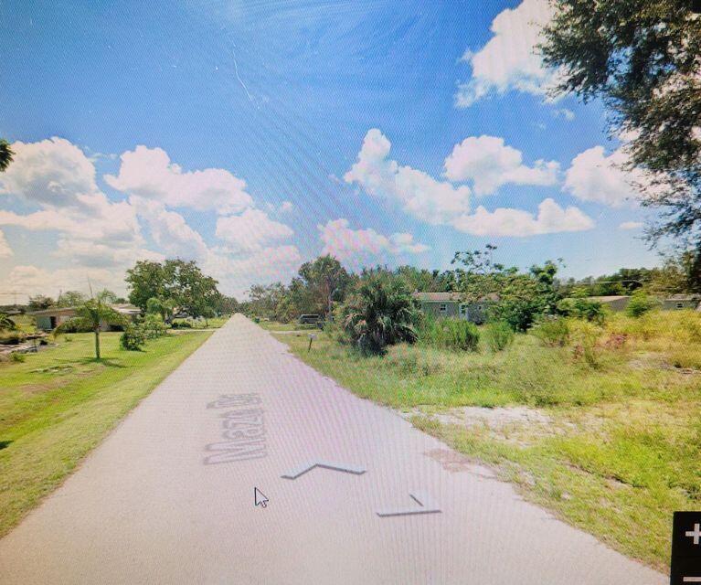 A paved road stretches through a rural residential area with scattered houses and grassy lots — 5385 Maze Drive, Punta Gorda FL 33982, PUNTA GORDA, FL