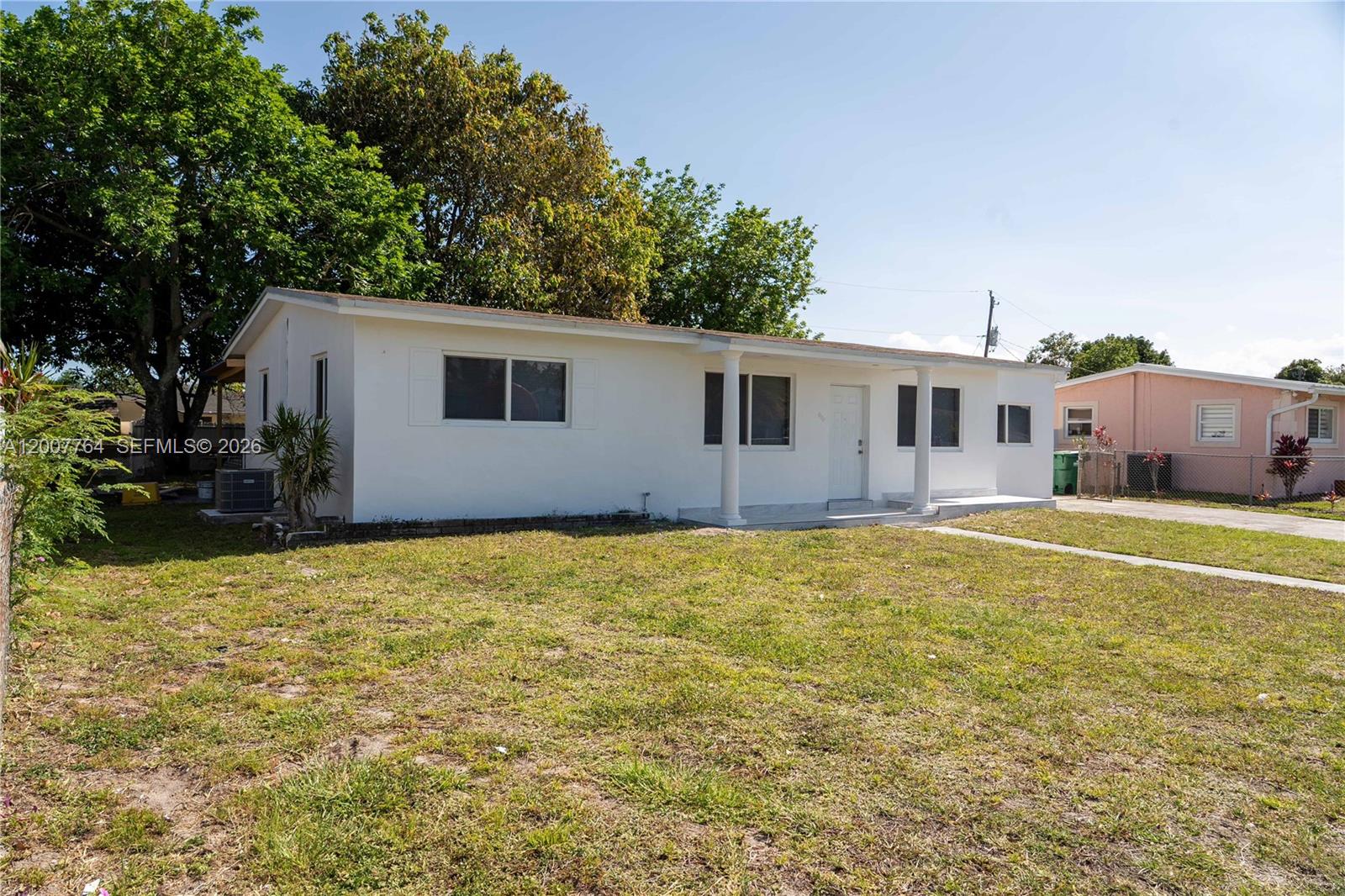 A white, single-story house with a front porch stands on a grassy lot — 4000 NW 195th St, Miami Gardens FL 33055, MIAMI GARDENS, FL