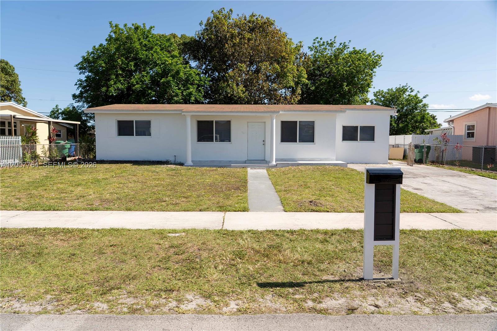 A single-story white house with a brown roof and a front lawn — 4000 NW 195th St, Miami Gardens FL 33055, MIAMI GARDENS, FL