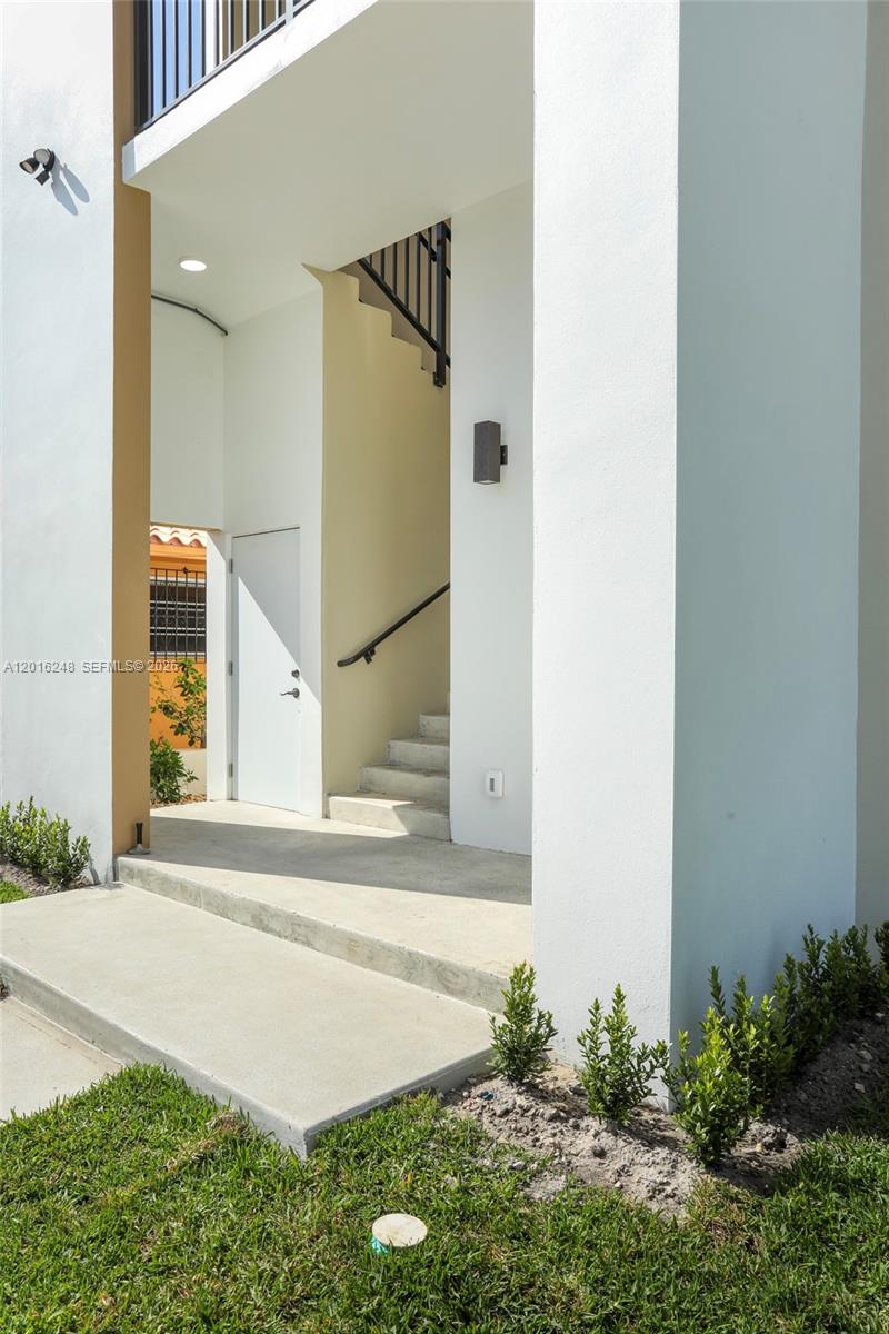 An outdoor entryway features concrete steps, a white door, and a staircase with railings — 120 SW 35 Ave # A2, Miami FL 33135, MIAMI, FL