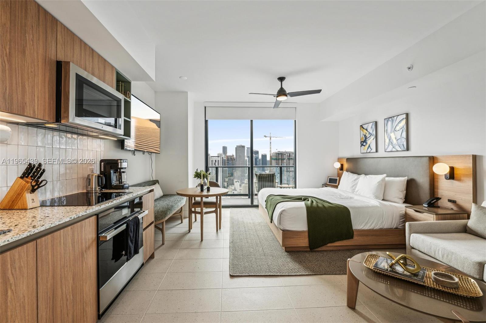 A studio apartment features a kitchen, dining area, and bed with a city view balcony — 159 NE 6th St # 3312, Miami FL 33132, MIAMI, FL