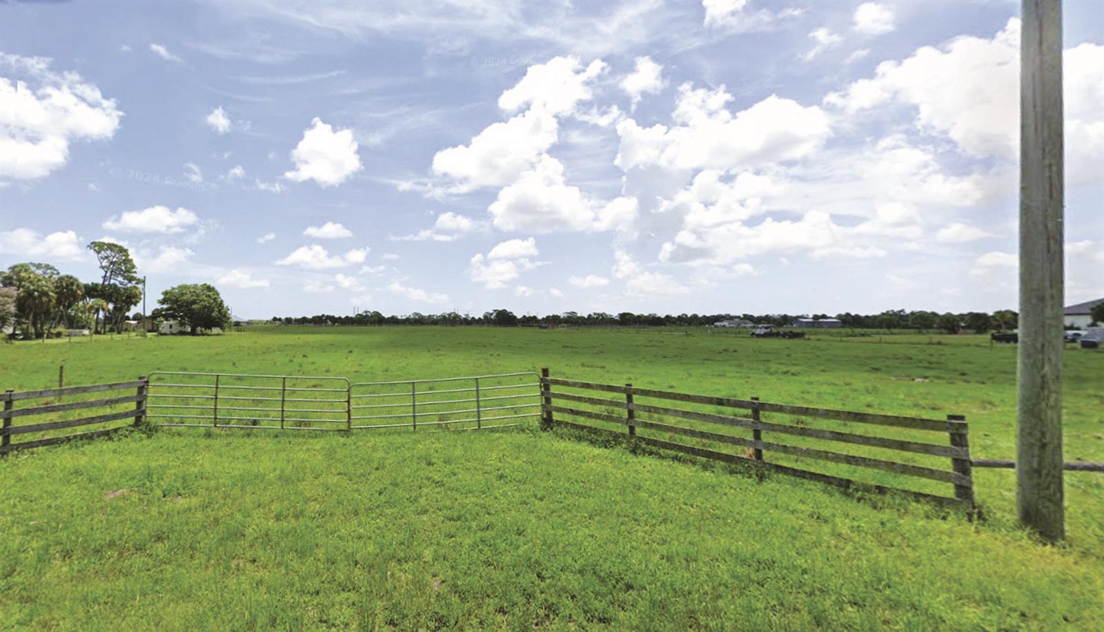 A wide, grassy field is enclosed by a wooden fence and a metal gate — Tbd S Brocksmith Road, Fort Pierce FL 34945, FORT PIERCE, FL