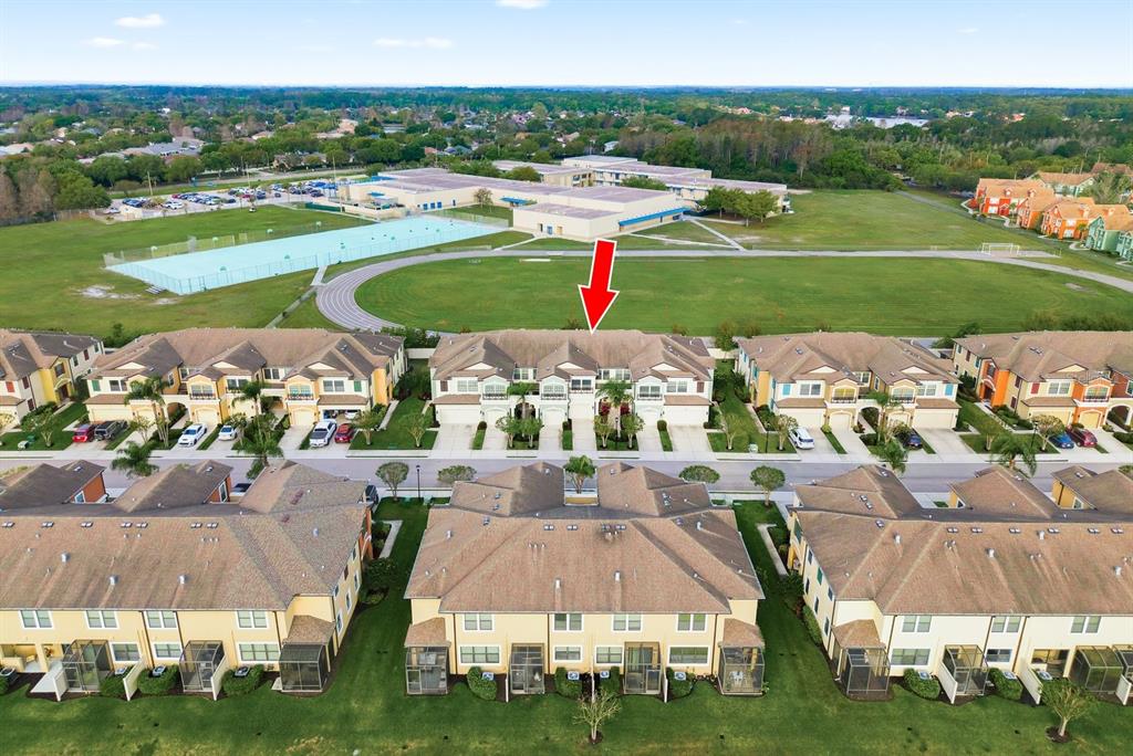 An aerial view shows a row of townhouses with a red arrow pointing toward one — 11636 CROWNED SPARROW LANE, TAMPA, FL