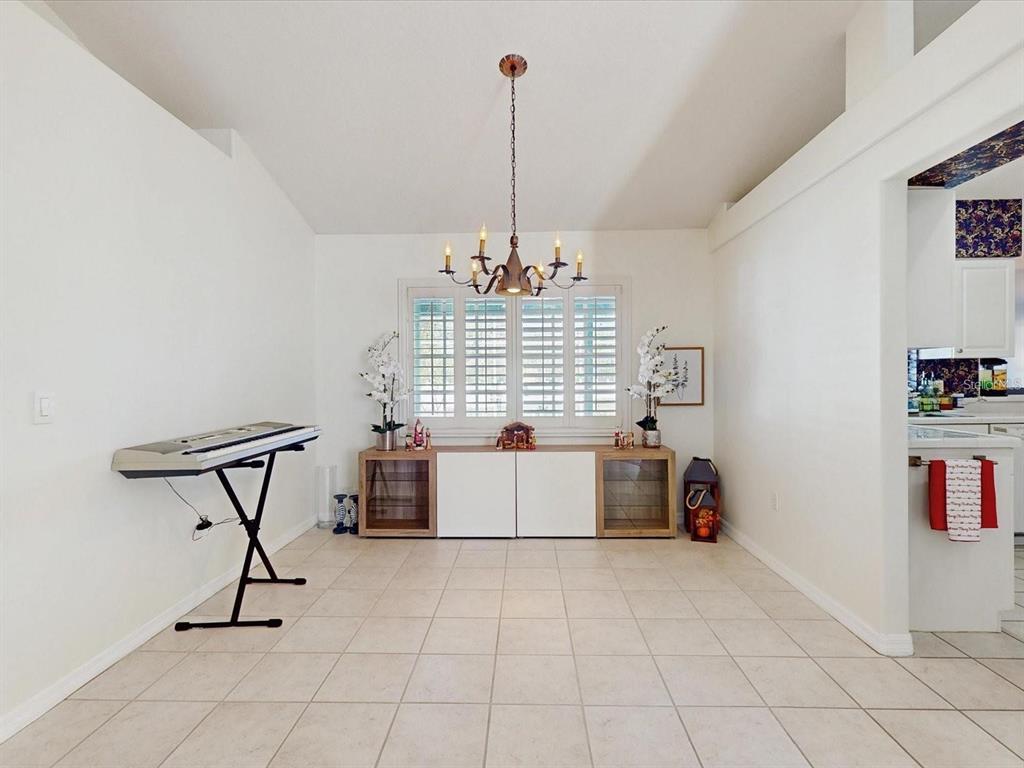 A dining area with tile floors, a chandelier, a keyboard stand, and a storage console — 2211 JESSICA LANE, KISSIMMEE, FL