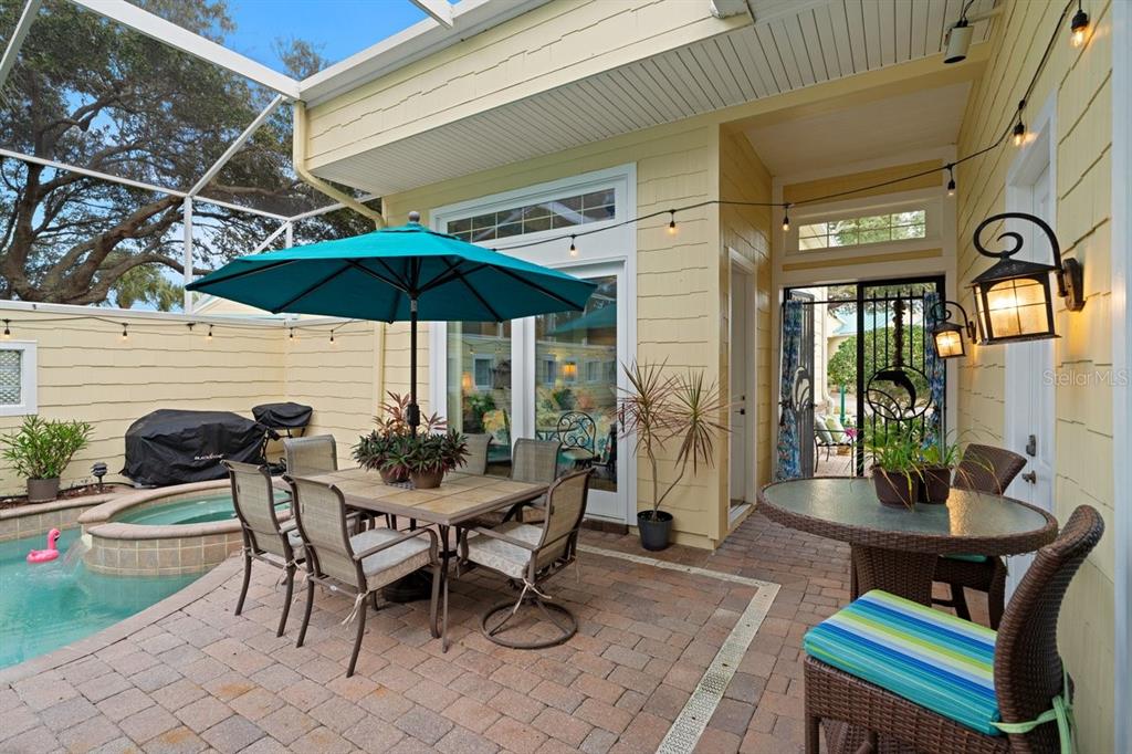 A covered patio features a dining set, a small table, and a pool with spa — 4606 OAK HAMMOCK COURT UNIT 4606, PONCE INLET, FL