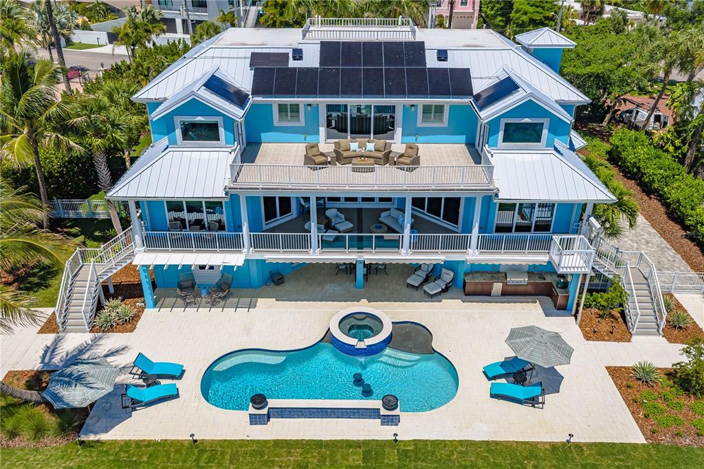 An aerial view of a bright blue house with a pool, spa, and large balconies — 350 S SHORE DRIVE, SARASOTA, FL