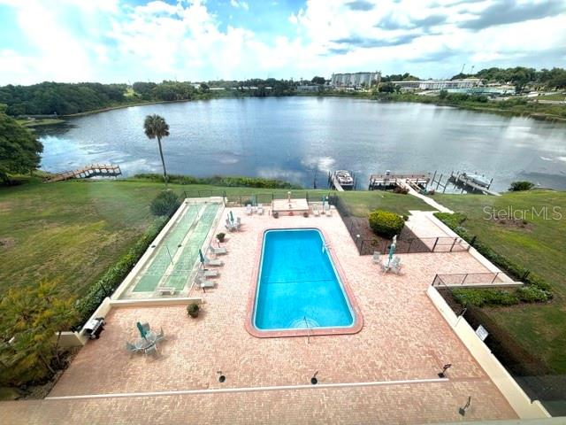 An aerial view shows a swimming pool and shuffleboard court overlooking a large lake — 700 MIRROR TERRACE NW UNIT 507, WINTER HAVEN, FL