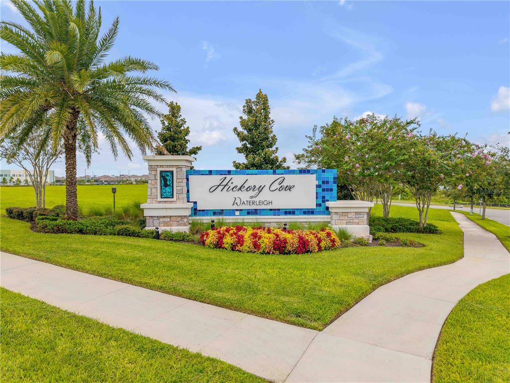 A stone and blue tile monument sign for Hickory Cove at Waterleigh stands outdoors — 9605 LOST CREEK DRIVE, WINTER GARDEN, FL