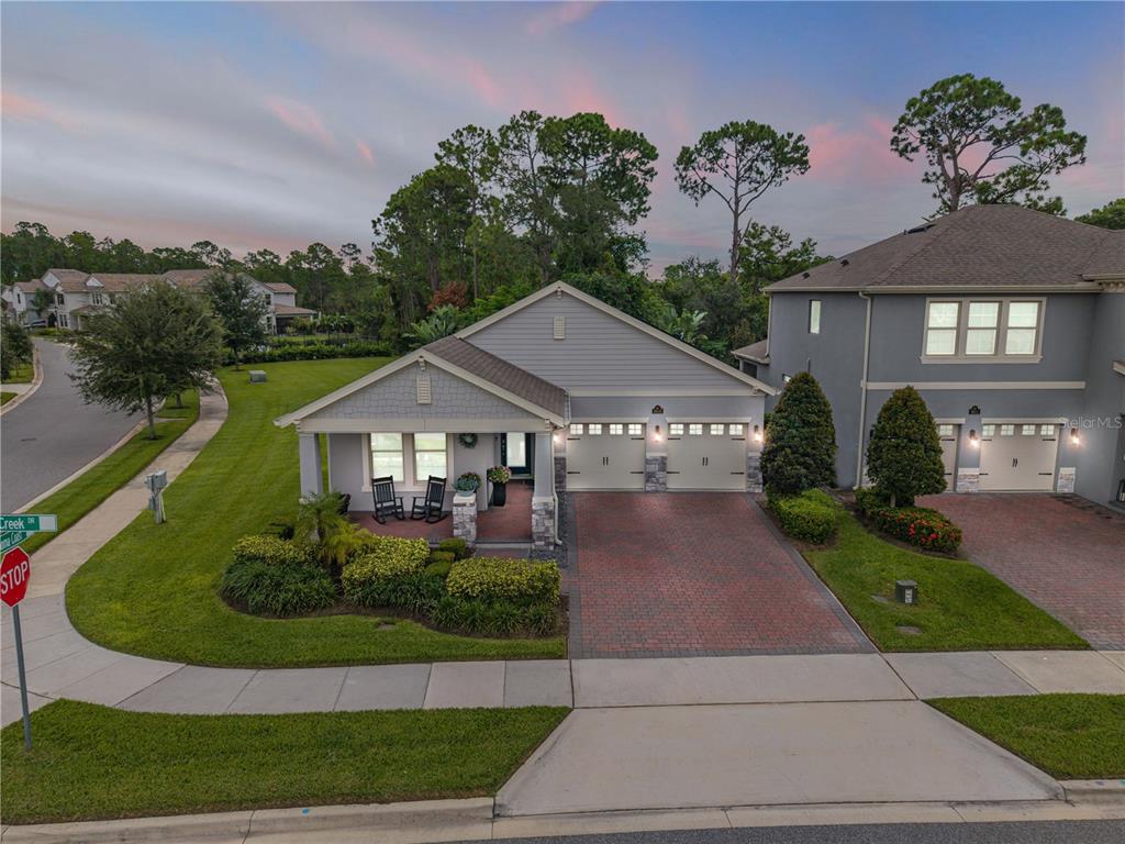 A single-story house with a brick driveway, two-car garage, and a covered front porch — 9605 LOST CREEK DRIVE, WINTER GARDEN, FL
