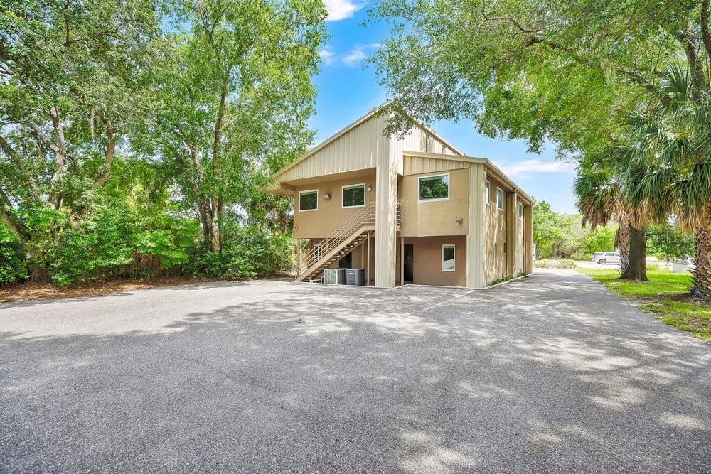 A two-story tan building with an exterior staircase stands in a paved parking lot — 925 W SR 434, WINTER SPRINGS, FL