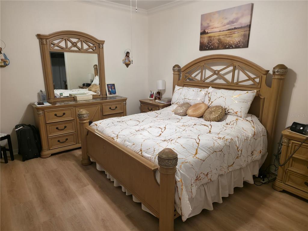 A bedroom features a light wood bed frame, matching dresser with mirror, and marble-patterned bedding — 14742 CLARKSON DRIVE, ORLANDO, FL