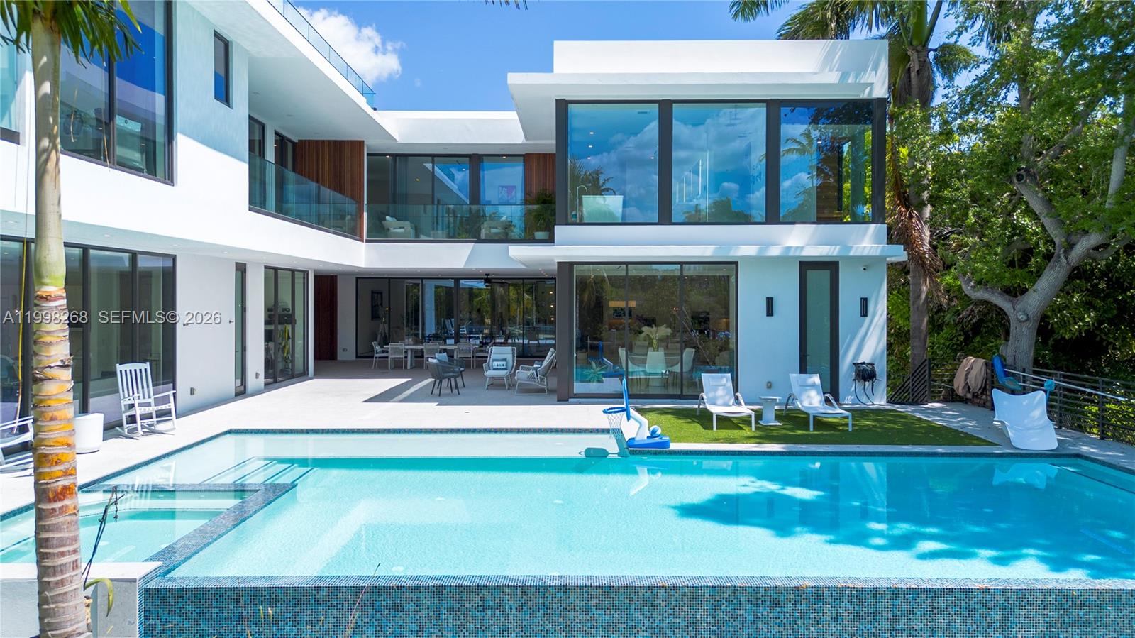 A modern two-story house features a swimming pool, patio, and large glass windows — 922 NE 78th St, Miami FL 33138, MIAMI, FL