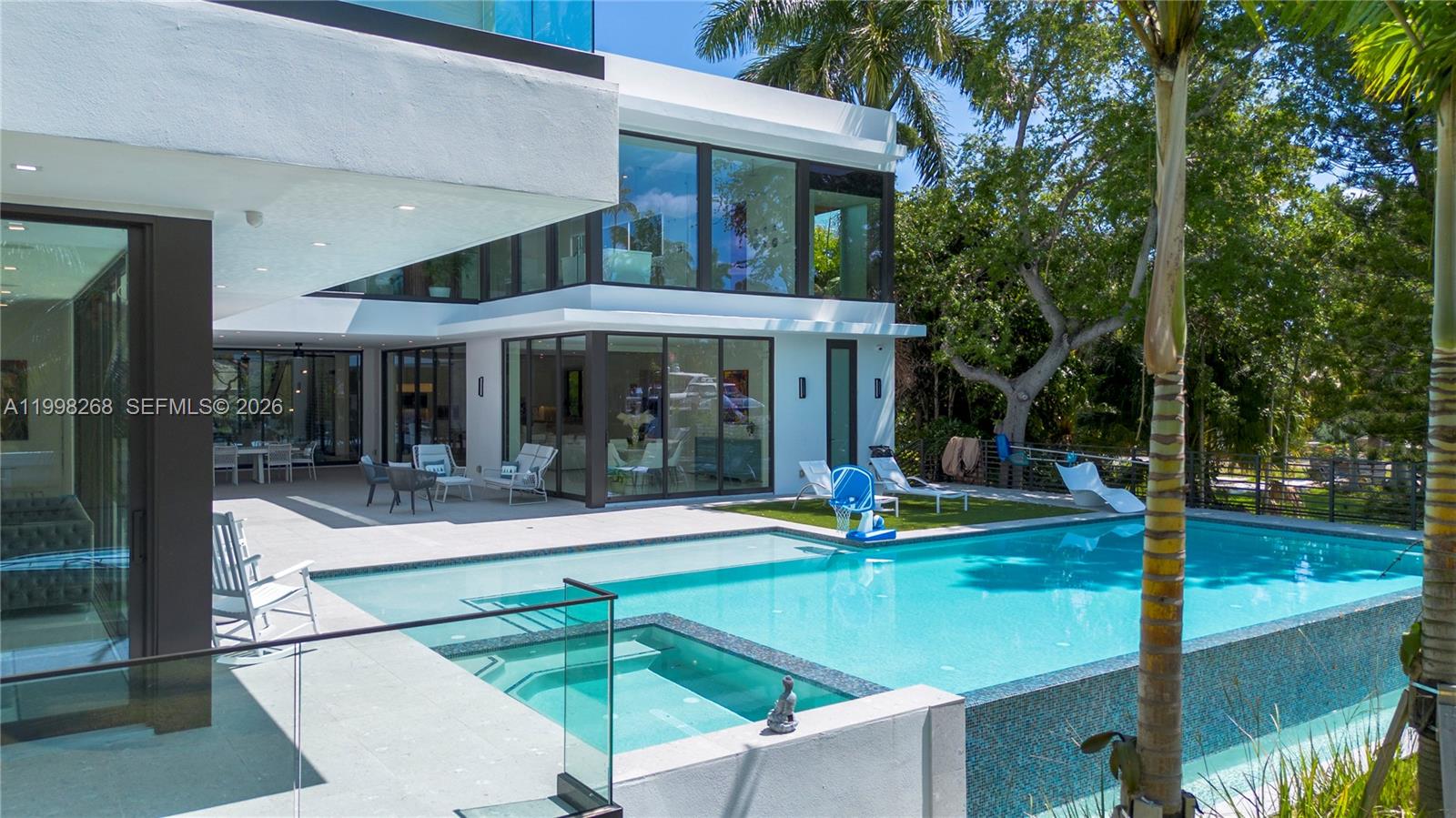 A modern two-story home features a swimming pool, a hot tub, and a patio area — 922 NE 78th St, Miami FL 33138, MIAMI, FL