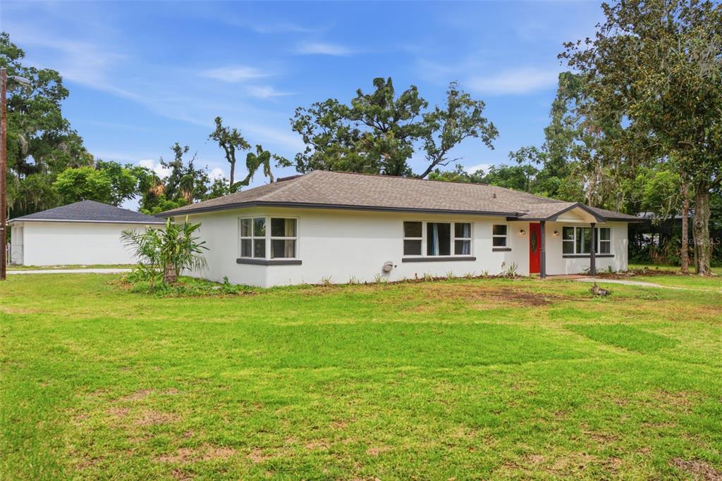 A white, single-story house with a red front door and a detached garage — 625 LIMONA ROAD, BRANDON, FL
