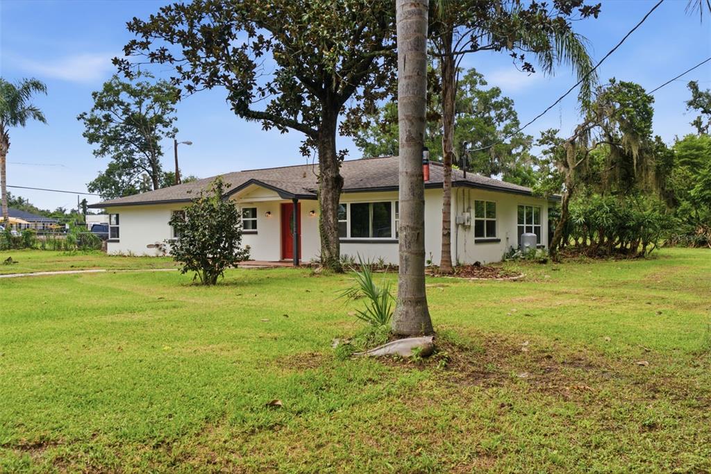 A single-story white house with a red front door sits on a grassy lot — 625 LIMONA ROAD, BRANDON, FL