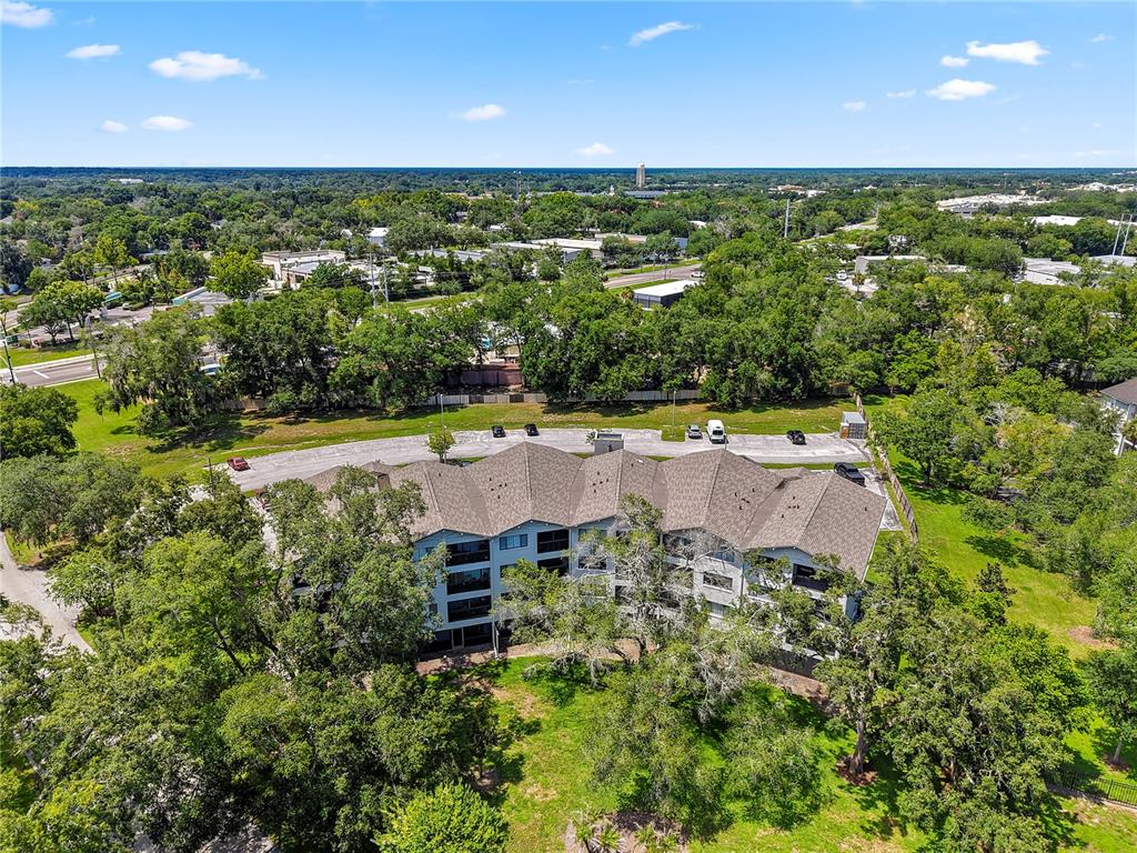 An aerial view shows a multi-story apartment building surrounded by trees and a parking lot — 1036 BONAIRE DRIVE UNIT 2834, ALTAMONTE SPRINGS, FL