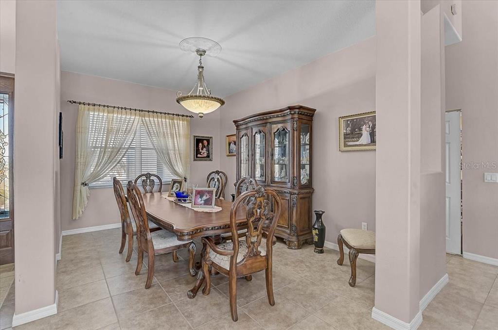 A dining room features a wooden table, matching chairs, a china cabinet, and tile flooring — 25202 E 61ST AVENUE, MYAKKA CITY, FL